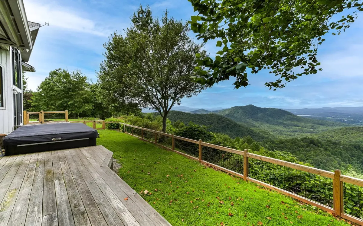 Here, the focus is on a wooden deck overlooking sweeping mountain views and surrounded by trees, inviting guests to relax, socialize, or stargaze. The deck is an ideal spot for informal gatherings or unwinding after team activities.