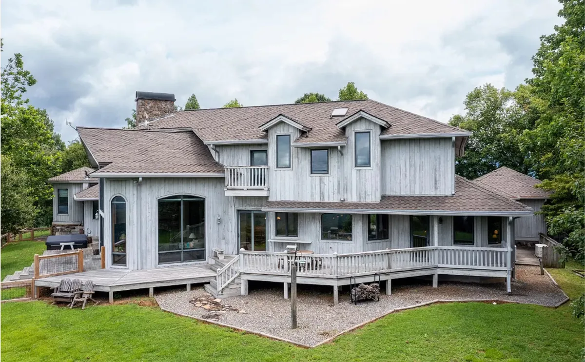 A wide view of the home’s expansive deck, large windows, and unique architectural features, all set against a tranquil natural backdrop. The space is ideal for outdoor relaxation, morning coffees, or evening barbecues, emphasizing seamless indoor-outdoor living.